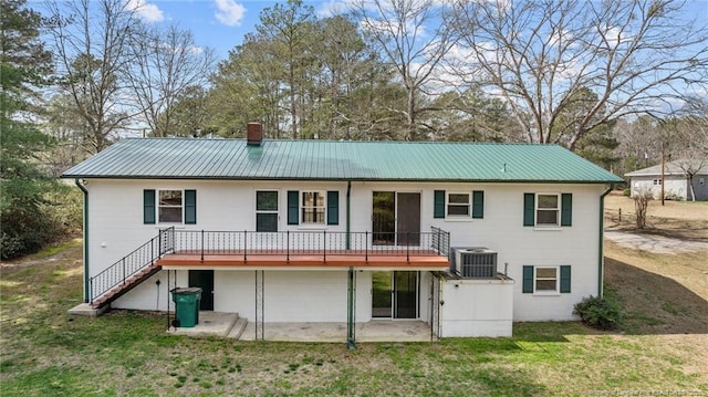 5027 Lake Willett Rd, Sanford, NC 27332 - back of property with metal roof, stairs, central AC unit, a lawn, and a deck