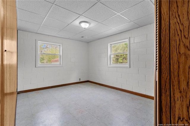 5027 Lake Willett Rd, Sanford, NC 27332 - empty room featuring tile patterned floors, a paneled ceiling, baseboards, and concrete block wall