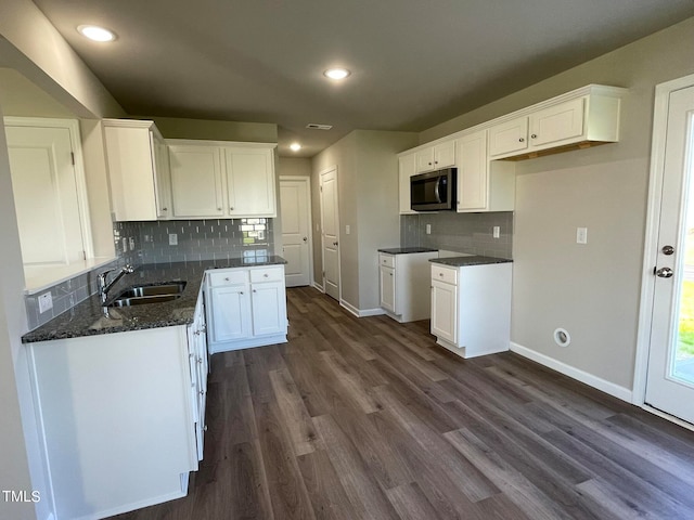 kitchen featuring white cabinets, tasteful backsplash, dark wood-type flooring, and sink