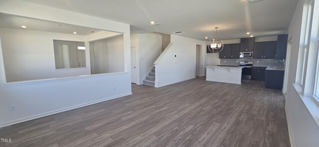 kitchen featuring stainless steel appliances, visible vents, open floor plan, light countertops, and dark wood-style floors