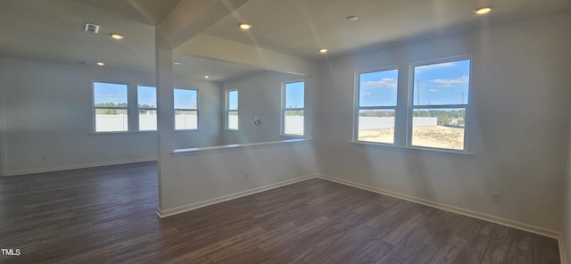 empty room featuring dark wood-type flooring, recessed lighting, and baseboards