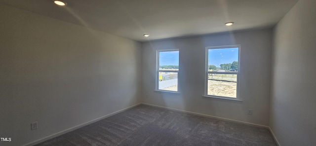 empty room with baseboards, dark carpet, and recessed lighting