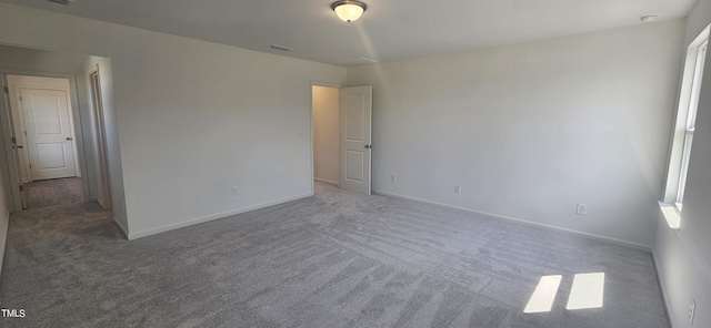 unfurnished bedroom featuring carpet, visible vents, and baseboards