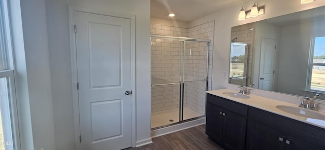 bathroom featuring wood finished floors, a stall shower, and a sink