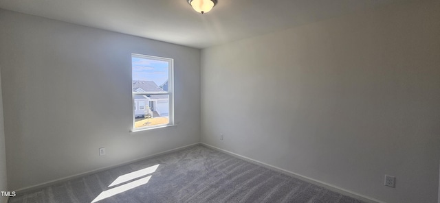 carpeted empty room featuring baseboards