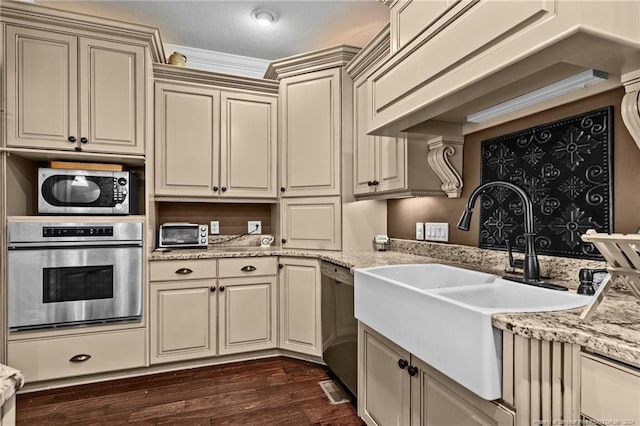 kitchen with light stone countertops, crown molding, dark hardwood / wood-style flooring, stainless steel appliances, and sink