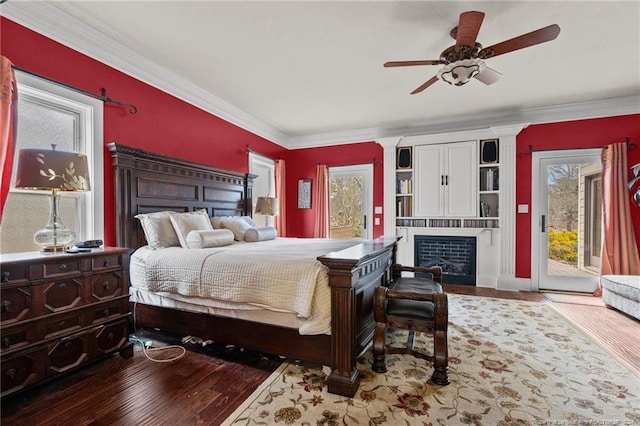 bedroom featuring multiple windows, ceiling fan, hardwood / wood-style flooring, and access to outside