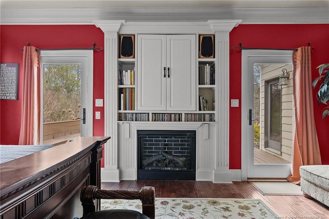 interior space featuring white cabinetry, ornamental molding, dark hardwood / wood-style floors, and decorative columns