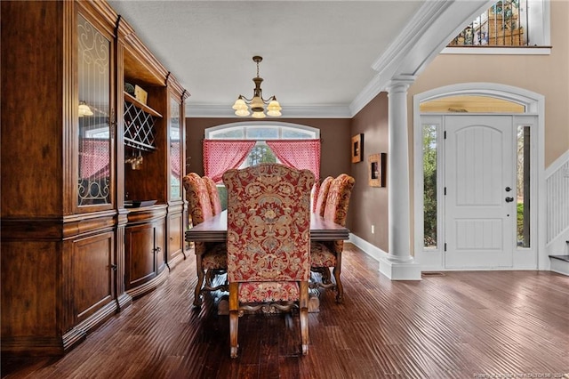 dining room with a notable chandelier, decorative columns, crown molding, and dark wood-type flooring