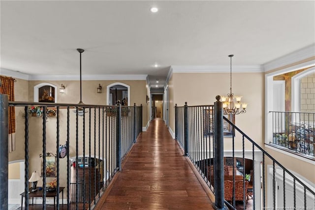 hall featuring dark hardwood / wood-style flooring, crown molding, and a notable chandelier