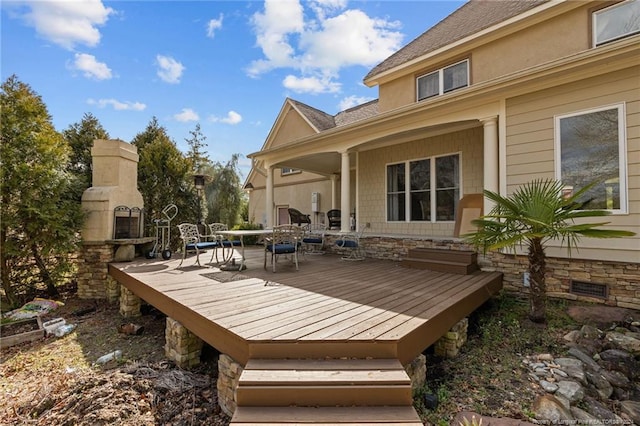 wooden terrace with an outdoor fireplace