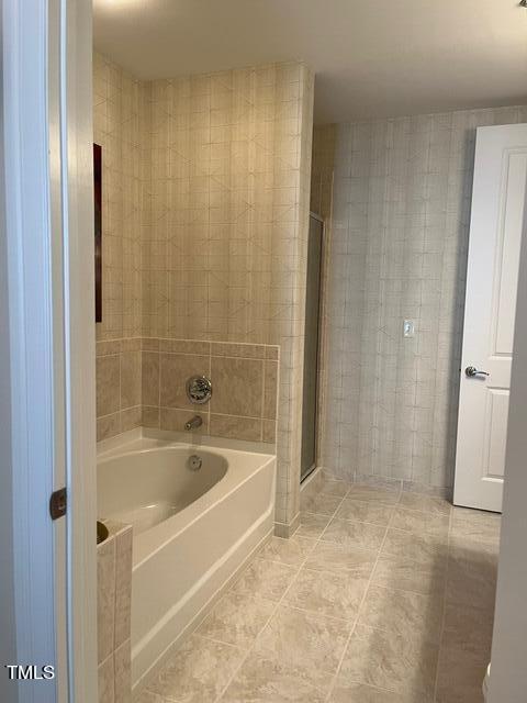 bathroom with shower with separate bathtub and tile floors