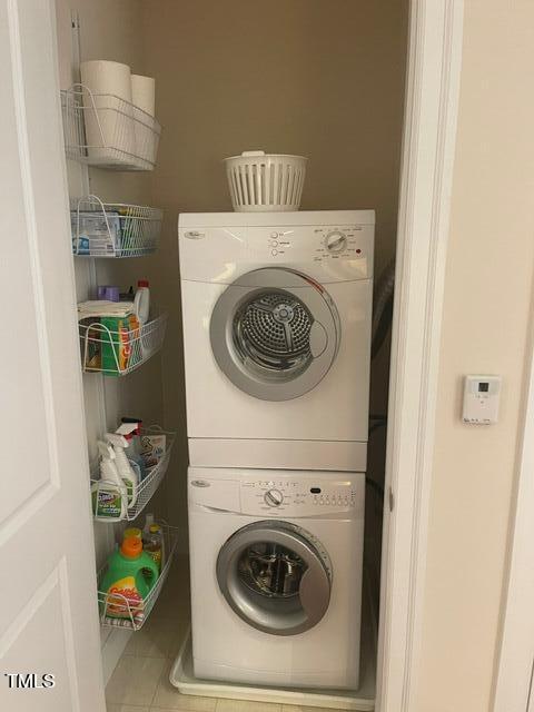 washroom featuring stacked washer / dryer and tile floors