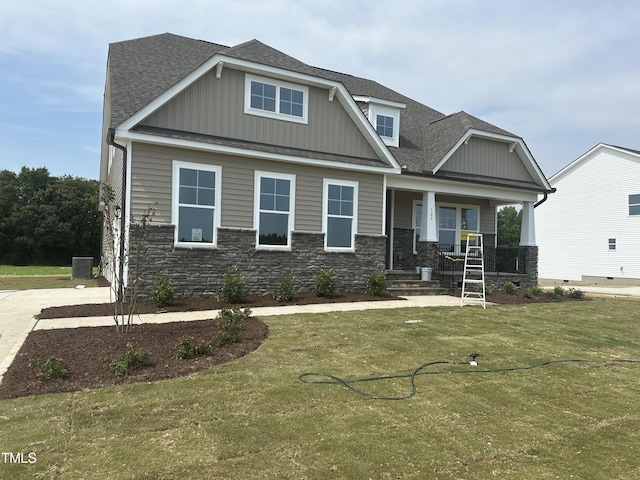 craftsman inspired home featuring a front yard, a porch, and central AC unit