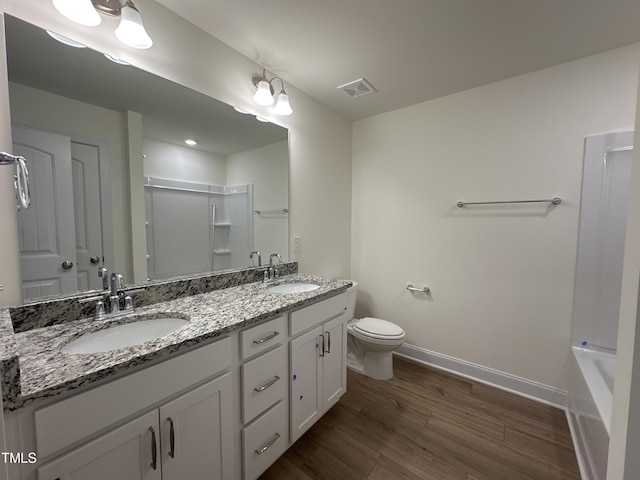 full bathroom with a shower, wood finished floors, a sink, and baseboards