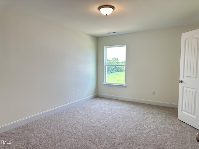 carpeted empty room with visible vents and baseboards