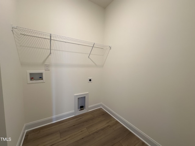 clothes washing area with washer hookup, dark wood-type flooring, electric dryer hookup, laundry area, and baseboards