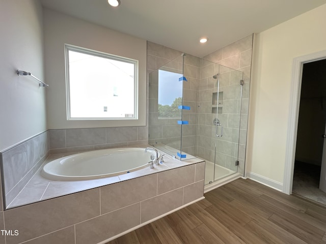 bathroom featuring a garden tub, recessed lighting, a shower stall, wood finished floors, and baseboards