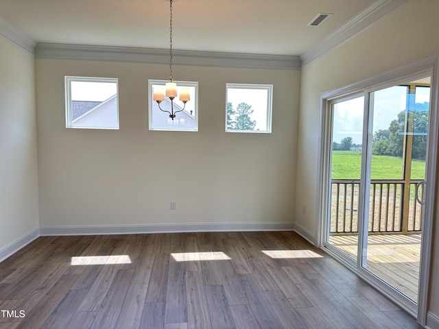 unfurnished dining area with baseboards, visible vents, wood finished floors, and ornamental molding