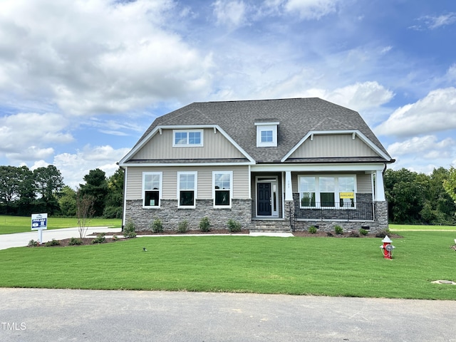 craftsman inspired home with a porch, roof with shingles, board and batten siding, and a front lawn