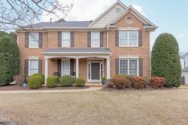 view of front of house with brick siding and a front lawn