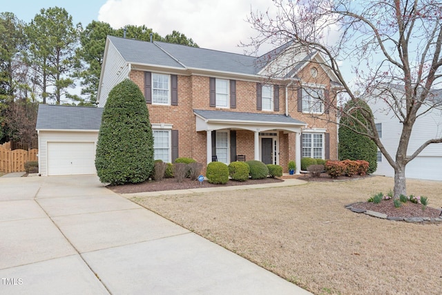 view of front of home with brick siding, driveway, a garage, and fence