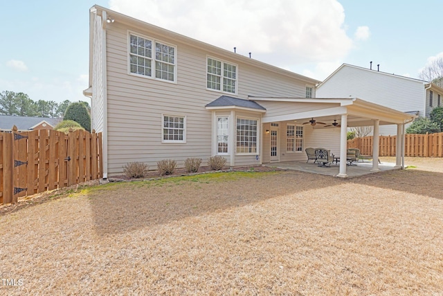 back of property with a fenced backyard, a ceiling fan, and a patio area