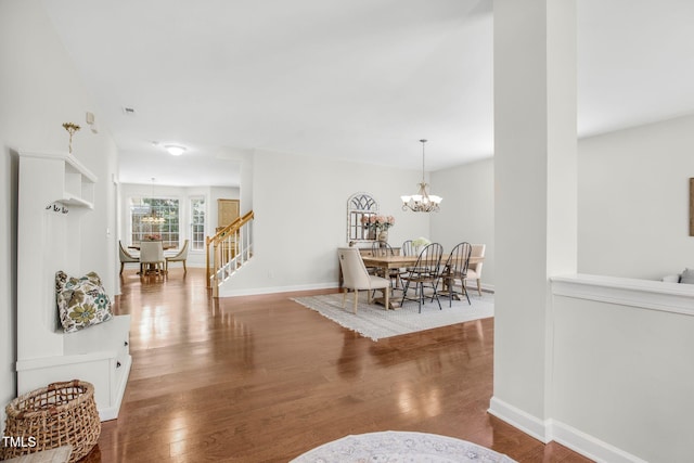 interior space with stairs, wood finished floors, baseboards, and a chandelier