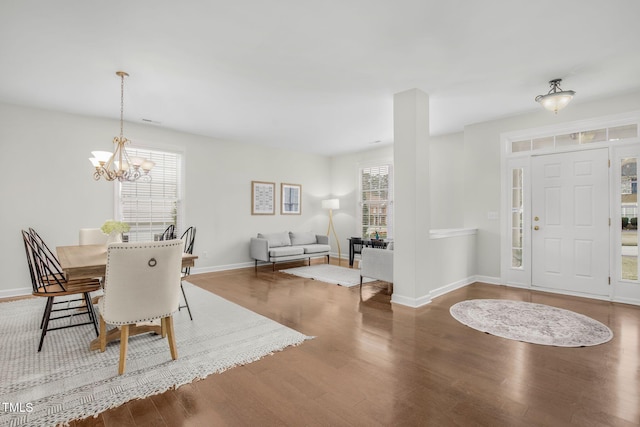 dining space featuring a chandelier, baseboards, and wood finished floors