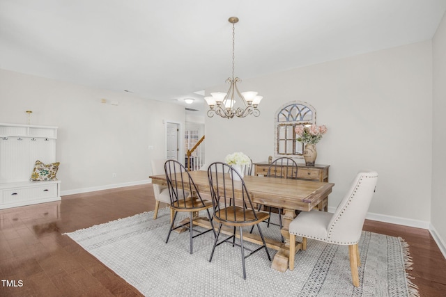 dining space featuring an inviting chandelier, stairway, wood finished floors, and baseboards