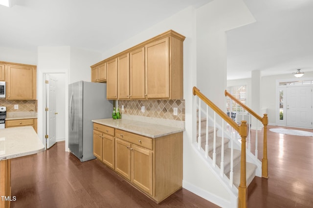 kitchen with light stone counters, dark wood-style floors, and freestanding refrigerator