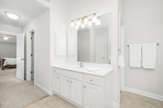 ensuite bathroom featuring vanity, tile patterned floors, baseboards, and connected bathroom