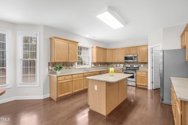 kitchen featuring light brown cabinetry, appliances with stainless steel finishes, and a center island