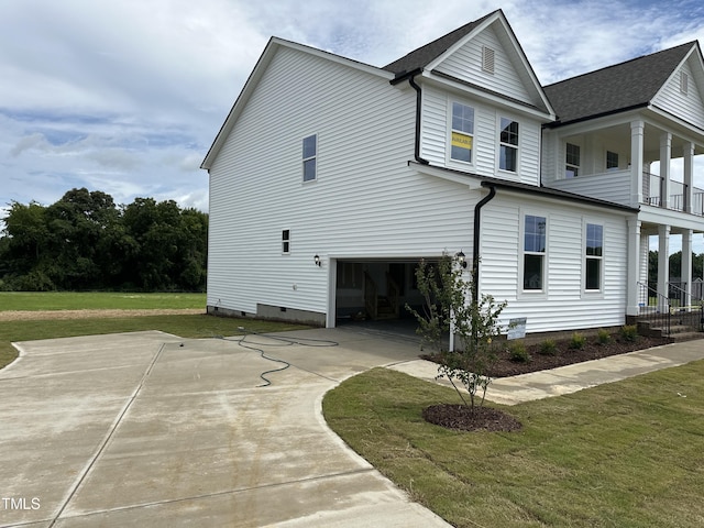 exterior space featuring crawl space, concrete driveway, a lawn, and an attached garage