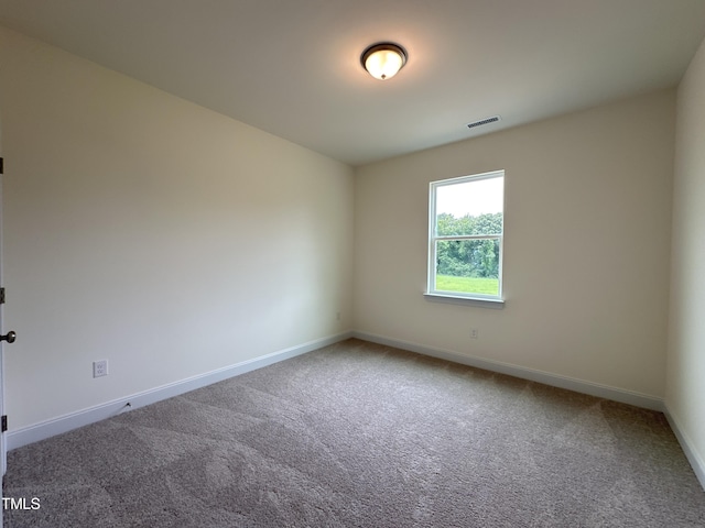 carpeted spare room featuring visible vents and baseboards