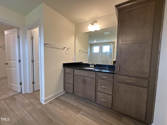 bathroom featuring wood finished floors, vanity, and baseboards