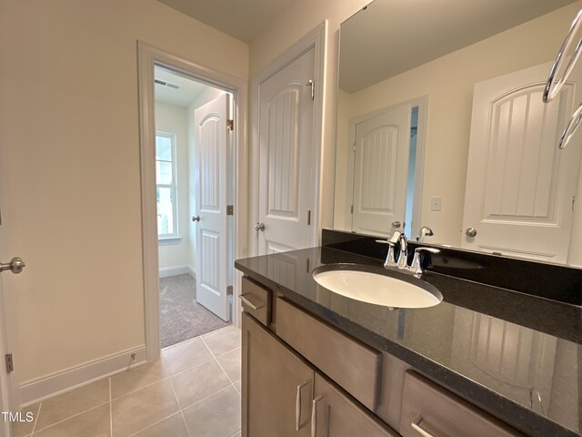 bathroom featuring tile patterned flooring, baseboards, and vanity