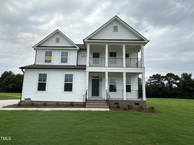 view of front of home featuring a front lawn, a balcony, and a porch