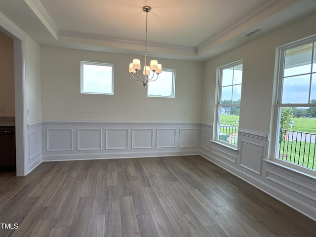 unfurnished dining area with a notable chandelier, visible vents, a raised ceiling, and dark wood-type flooring