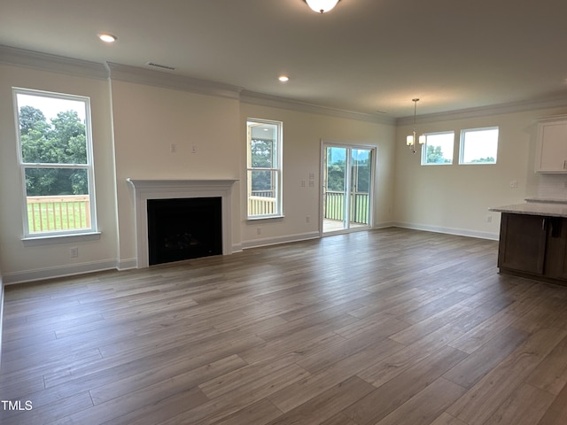 unfurnished living room with a fireplace, baseboards, crown molding, and wood finished floors