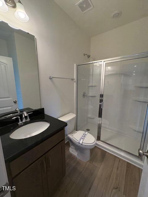123 Sage Ln Unit 010, Four Oaks, NC 27524 - full bath with a stall shower, wood finished floors, toilet, and vanity