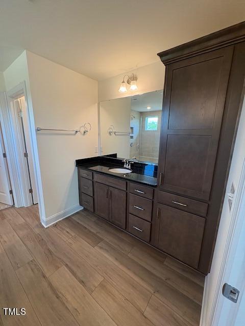 123 Sage Ln Unit 010, Four Oaks, NC 27524 - full bathroom featuring wood finished floors, vanity, a shower, and baseboards