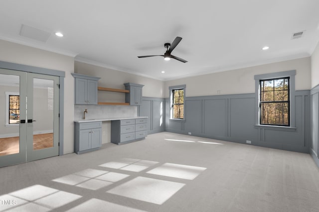 interior space with light colored carpet, a sink, visible vents, french doors, and built in study area