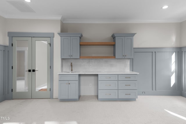 kitchen featuring light carpet, visible vents, light countertops, open shelves, and a sink