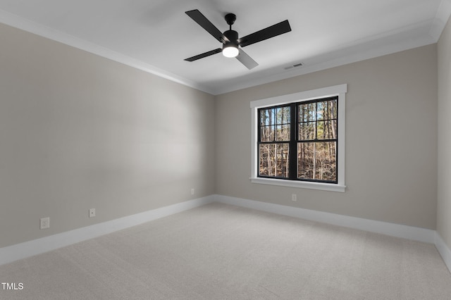 carpeted empty room with baseboards, visible vents, ceiling fan, and ornamental molding