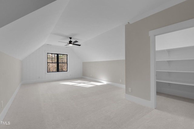 bonus room with lofted ceiling, ceiling fan, baseboards, and light colored carpet