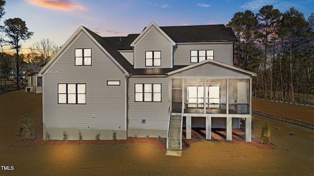 rear view of house featuring a sunroom and stairway