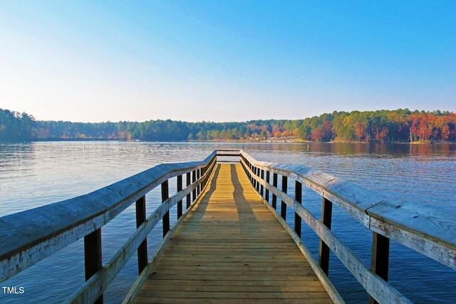 view of dock featuring a water view and a wooded view