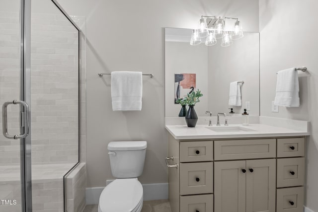 full bathroom featuring baseboards, tiled shower, vanity, and toilet