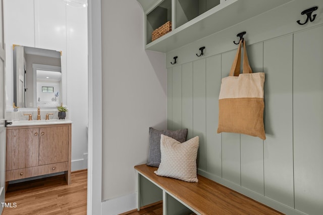 mudroom with light wood-style floors and a sink